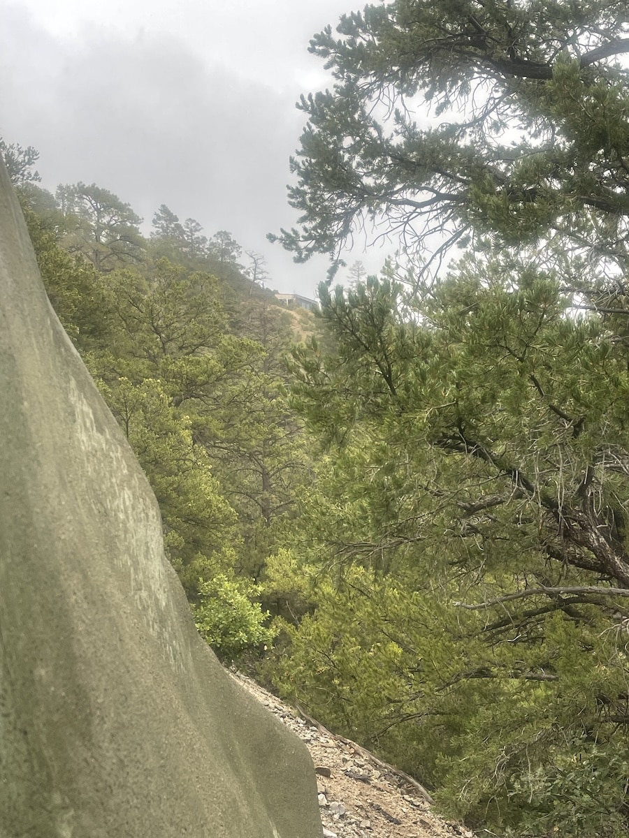 a photo of the near mountainside next to ou rhome, while it's raining.